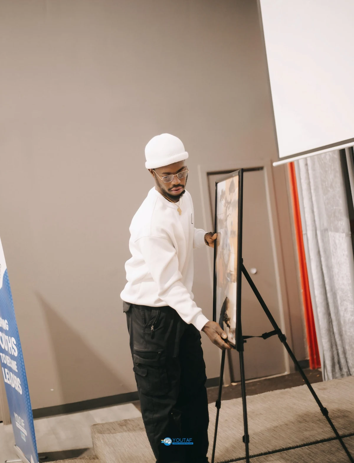 Barnes Adevu positioning artwork on an easel